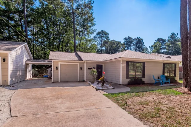a view of a house with a patio and a yard