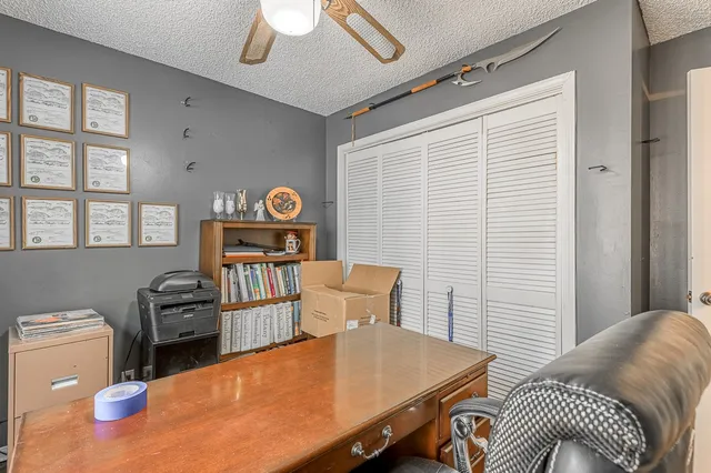 a view of a workspace with furniture and window