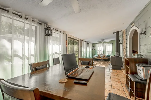 a living room with furniture floor to ceiling window and a flat screen tv