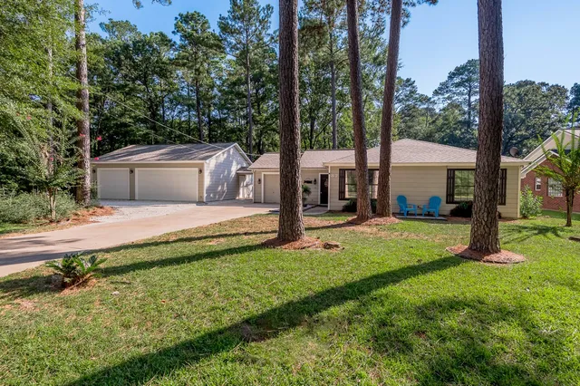 a view of a house with backyard and sitting area