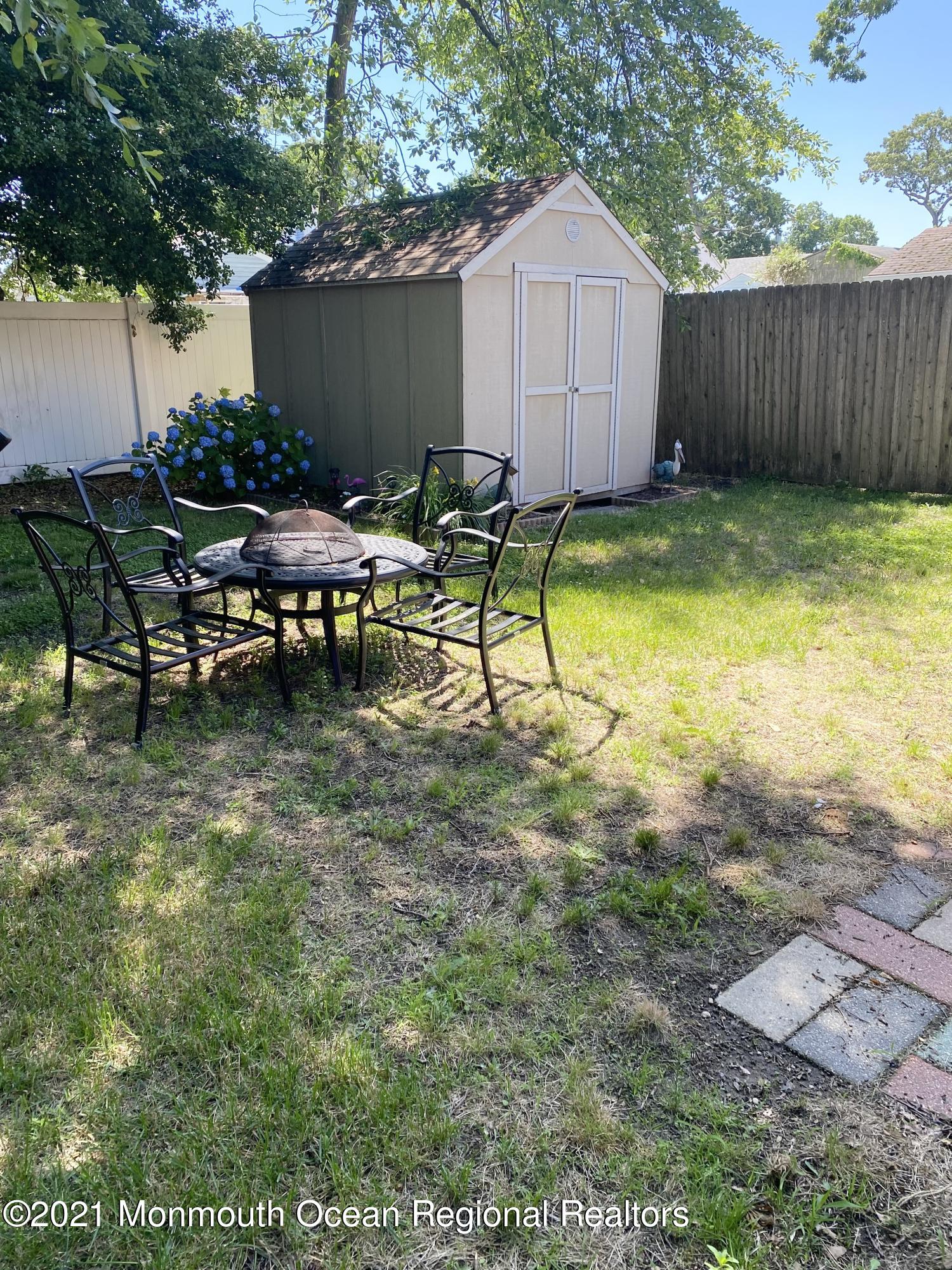 103 George Road Toms River, NJ 08753 - Photo 30 of 34 a view of a backyard with table and chairs and wooden fence