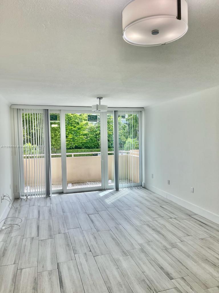 8050 Northwest 8th Street, Unit 201 Miami, FL 33126 - Photo 6 of 13 an empty room with wooden floor and windows