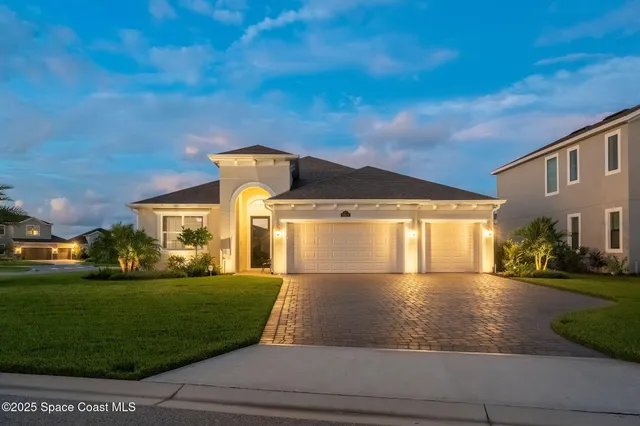 a view of a big house with a big yard plants and large trees