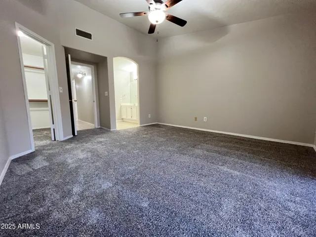 a view of an empty room with a chandelier fan