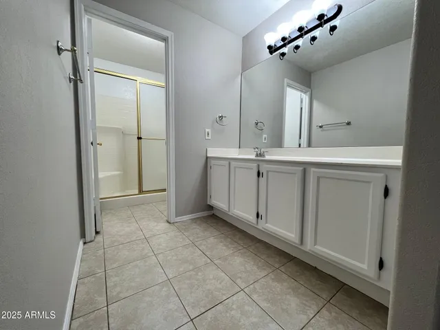 a spacious bathroom with a mirror and a shower