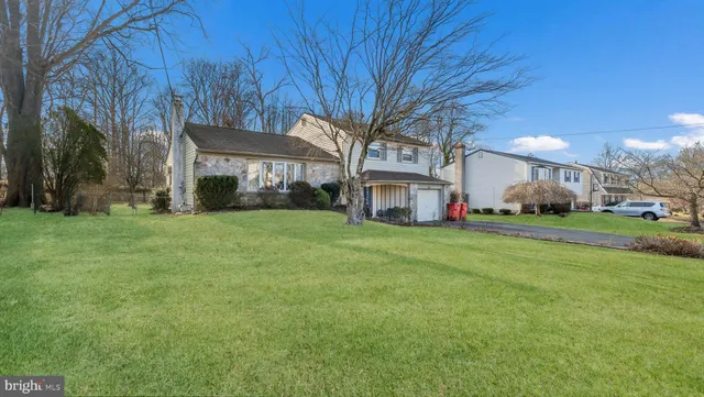 a view of a house with a big yard with large trees