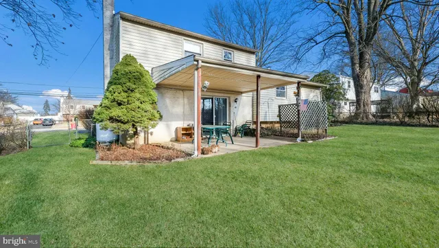a view of a house with a backyard and sitting area