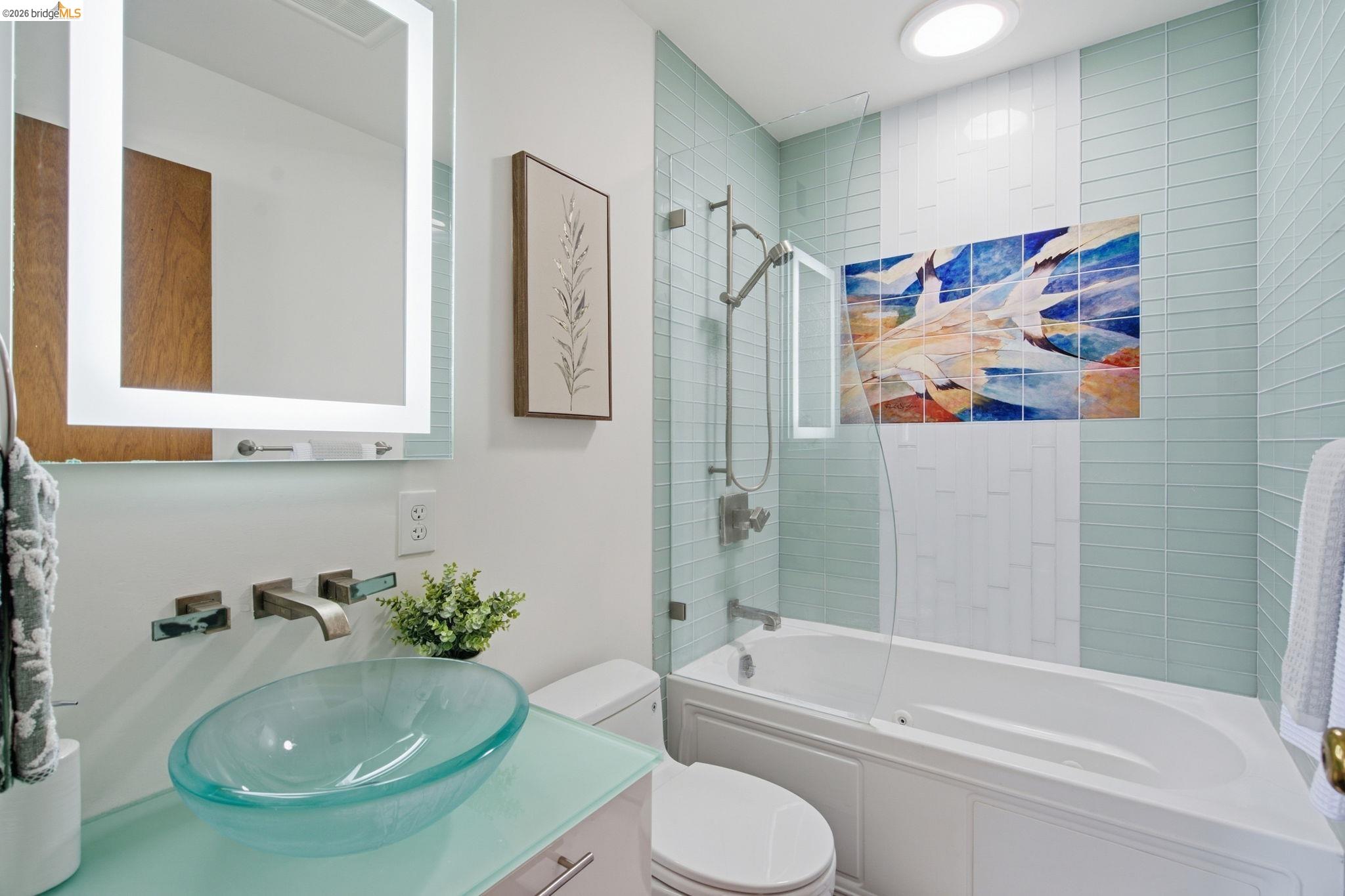 4522 Santa Rita Road El Sobrante, CA 94803 - Photo 23 of 58 Illuminated vanity mirror, wall-mounted faucet, glass vessel sink, glass shower panel, and subway tile tub surround