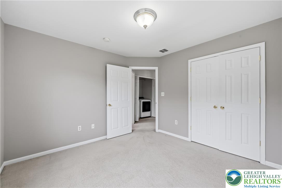 5607 Spring Ridge Drive West Macungie, PA 18062 - Photo 12 of 26 Plush carpeting and a neutral color palette define this versatile secondary bedroom space.