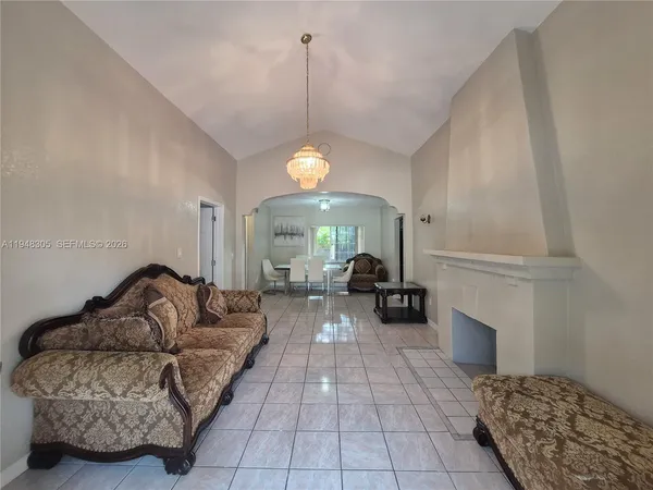 a living room with furniture a fireplace and a chandelier
