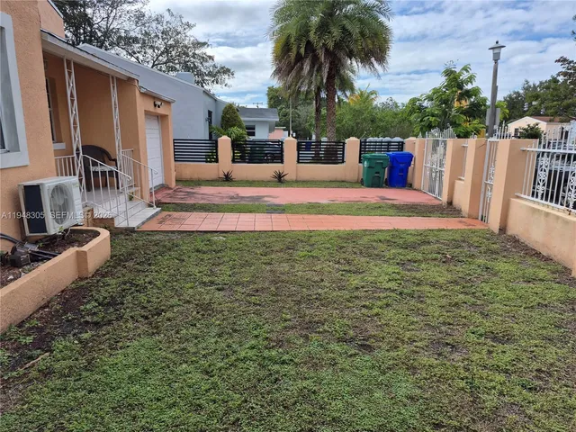 a view of a house with backyard and a patio