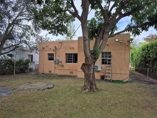 a white house that has a tree in front of it