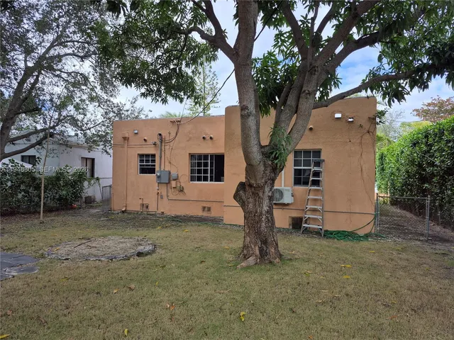 a white house that has a tree in front of it