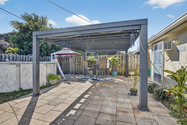 a view of a roof deck with wooden floor and fence next to a yard