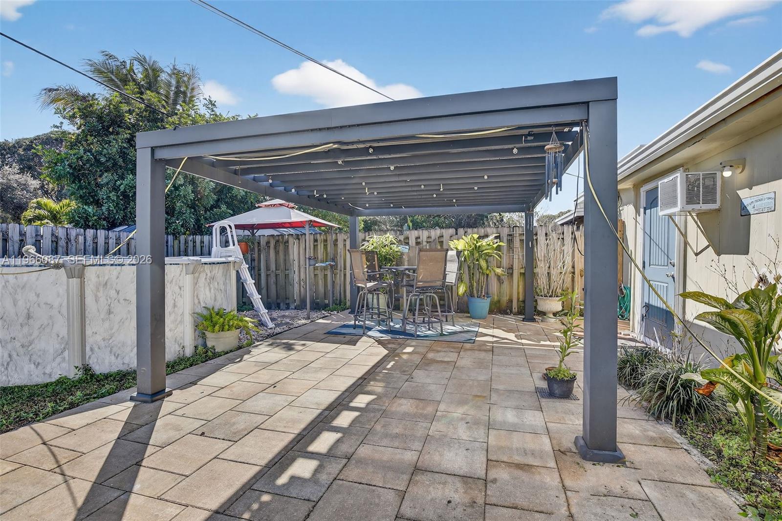 4998 Southwest 92nd Terrace Cooper City, FL 33328 - Photo 29 of 47 a view of a patio with table and chairs a barbeque with wooden fence
