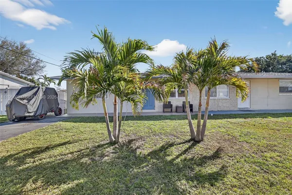 a front view of a house with a yard and potted plants