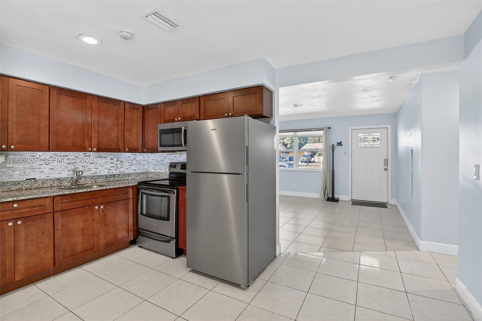 4998 Southwest 92nd Terrace Cooper City, FL 33328 - Photo 7 of 47 a kitchen with granite countertop a refrigerator and a sink