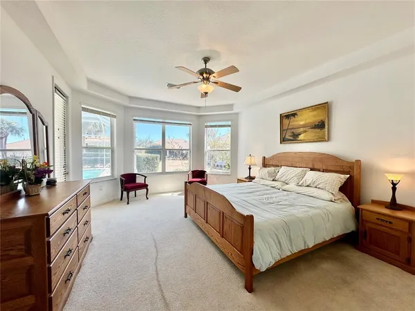 a spacious bedroom with a bed a couch and a chandelier