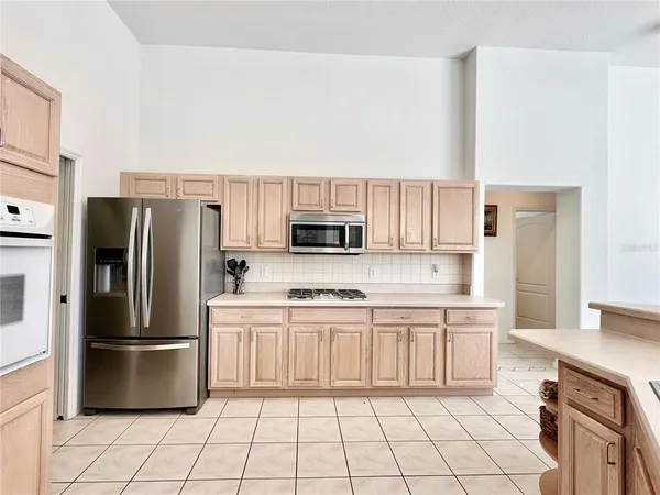 a kitchen with stainless steel appliances a refrigerator sink and microwave