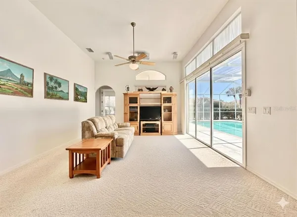 a view of a livingroom with furniture wooden floor windows and a fireplace