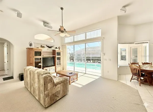 a view of a livingroom with furniture window and a kitchen