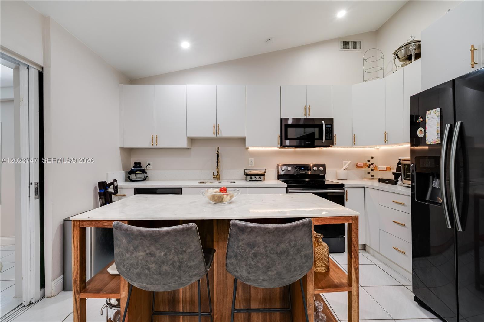 11515 Southwest 81st Road, Unit 11515 Pinecrest, FL 33156 - Photo 8 of 33 a kitchen with stainless steel appliances granite countertop a stove a refrigerator a sink a dining table and chairs