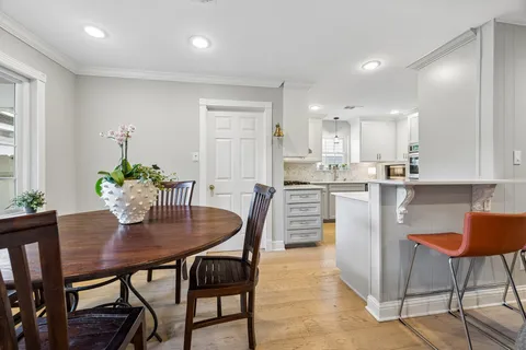 a kitchen with a dining table chairs and refrigerator