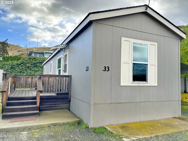 a view of a small house with wooden floor in front of house