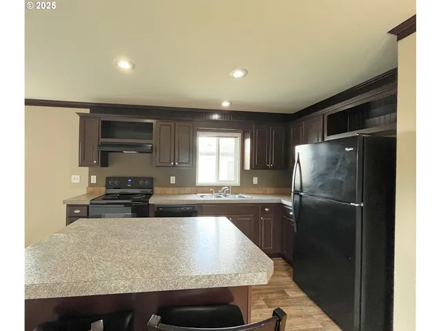 a kitchen with stainless steel appliances granite countertop a refrigerator and a sink