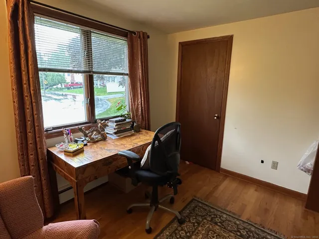 a view of a workspace with furniture and a window