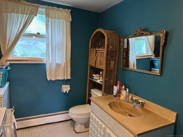 a bathroom with a toilet sink and mirror