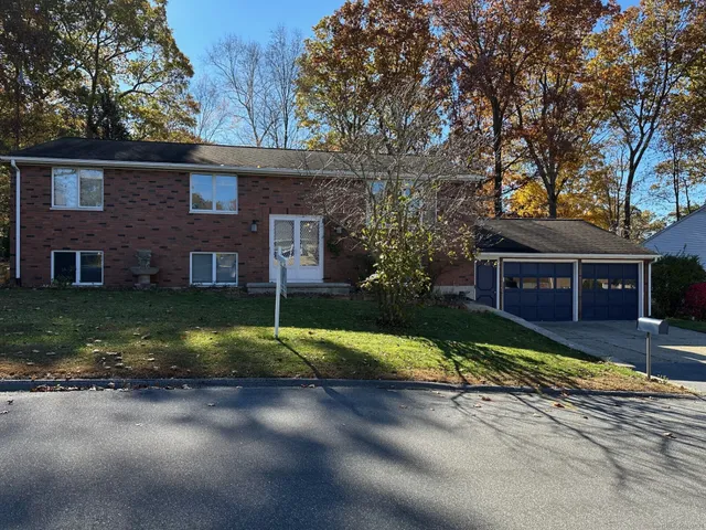 a view of a house with a yard garage and tree s