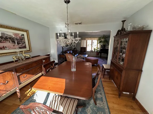 a view of a dining room with furniture a chandelier and wooden floor