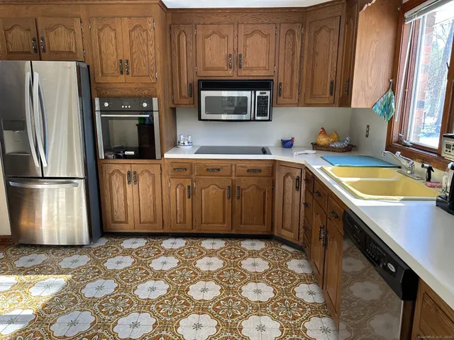 a kitchen with stainless steel appliances granite countertop a refrigerator stove and sink