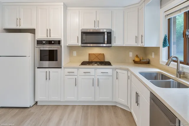 a kitchen with white cabinets and stainless steel appliances