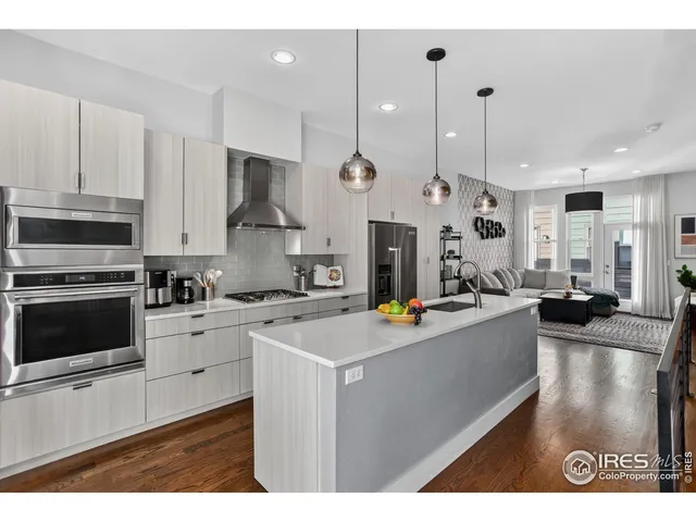 a kitchen with stainless steel appliances kitchen island granite countertop a sink a stove and a refrigerator