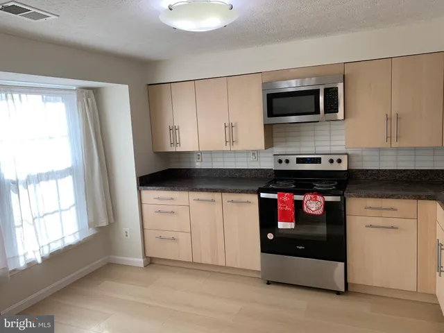 a kitchen with stainless steel appliances granite countertop a stove and a microwave