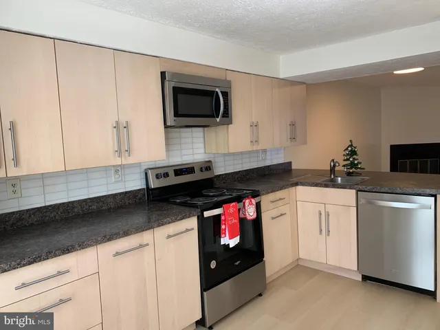 a kitchen with stainless steel appliances granite countertop a sink and a stove