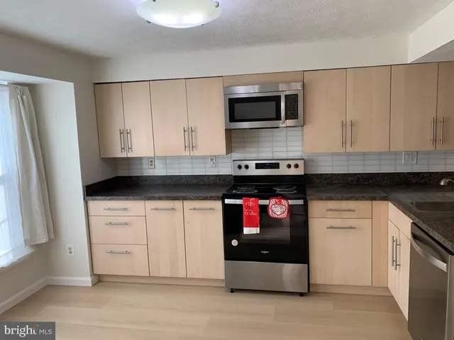 a kitchen with stainless steel appliances granite countertop a stove and a microwave