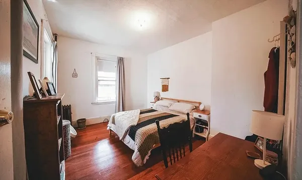 a bedroom with a bed and wooden floor