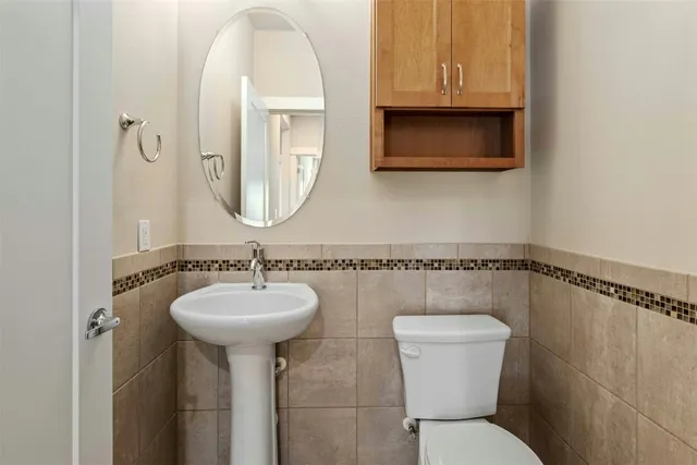 a bathroom with a toilet sink and mirror