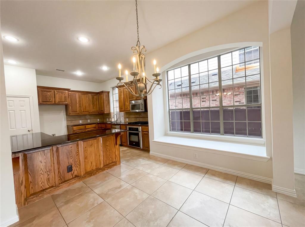 2128 Chambers Drive Allen, TX 75013 - Photo 12 of 23 a large kitchen with granite countertop a large counter top space appliances and cabinets