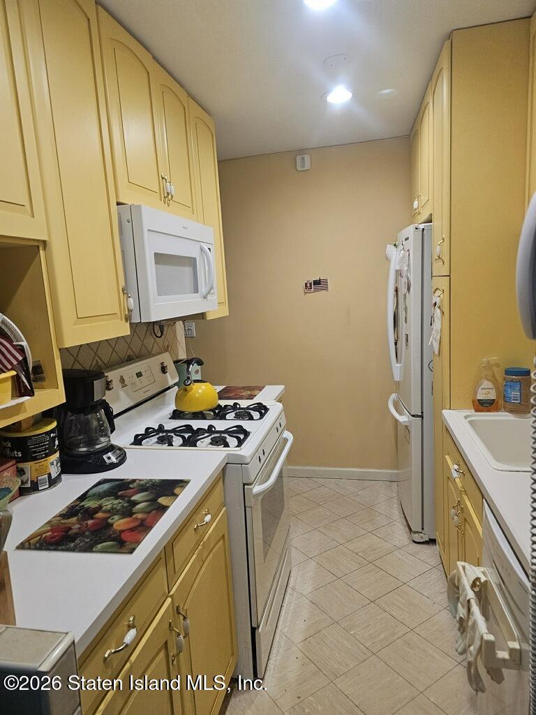 1100 Clove Road, Unit 5G Staten Island, NY 10301 - Photo 4 of 14 a kitchen that has a stove and a refrigerator