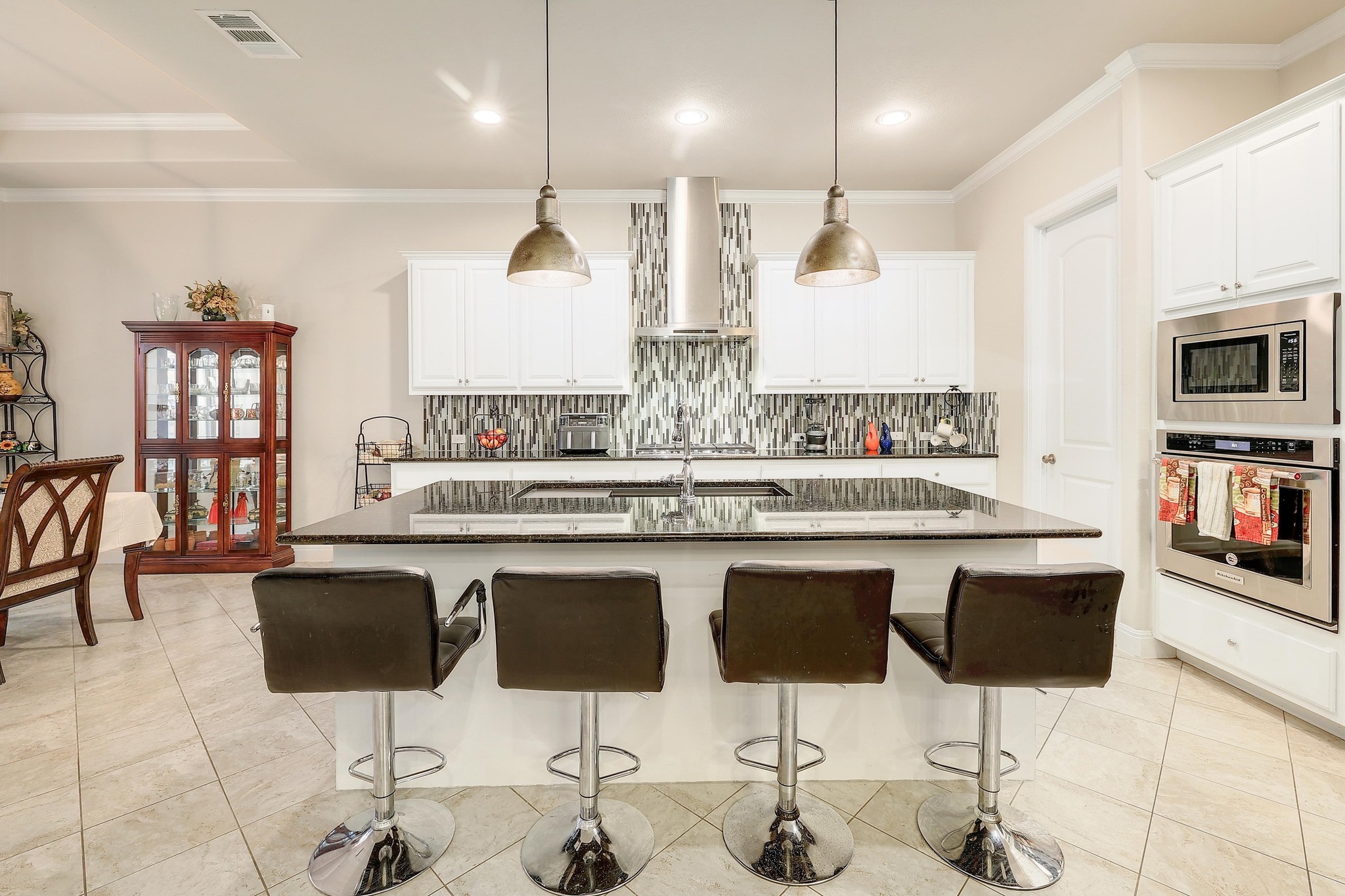 249 Axis Loop Georgetown, TX 78628 - Photo 11 of 36 a kitchen with stainless steel appliances kitchen island granite countertop a kitchen island a chairs in it and wooden floors
