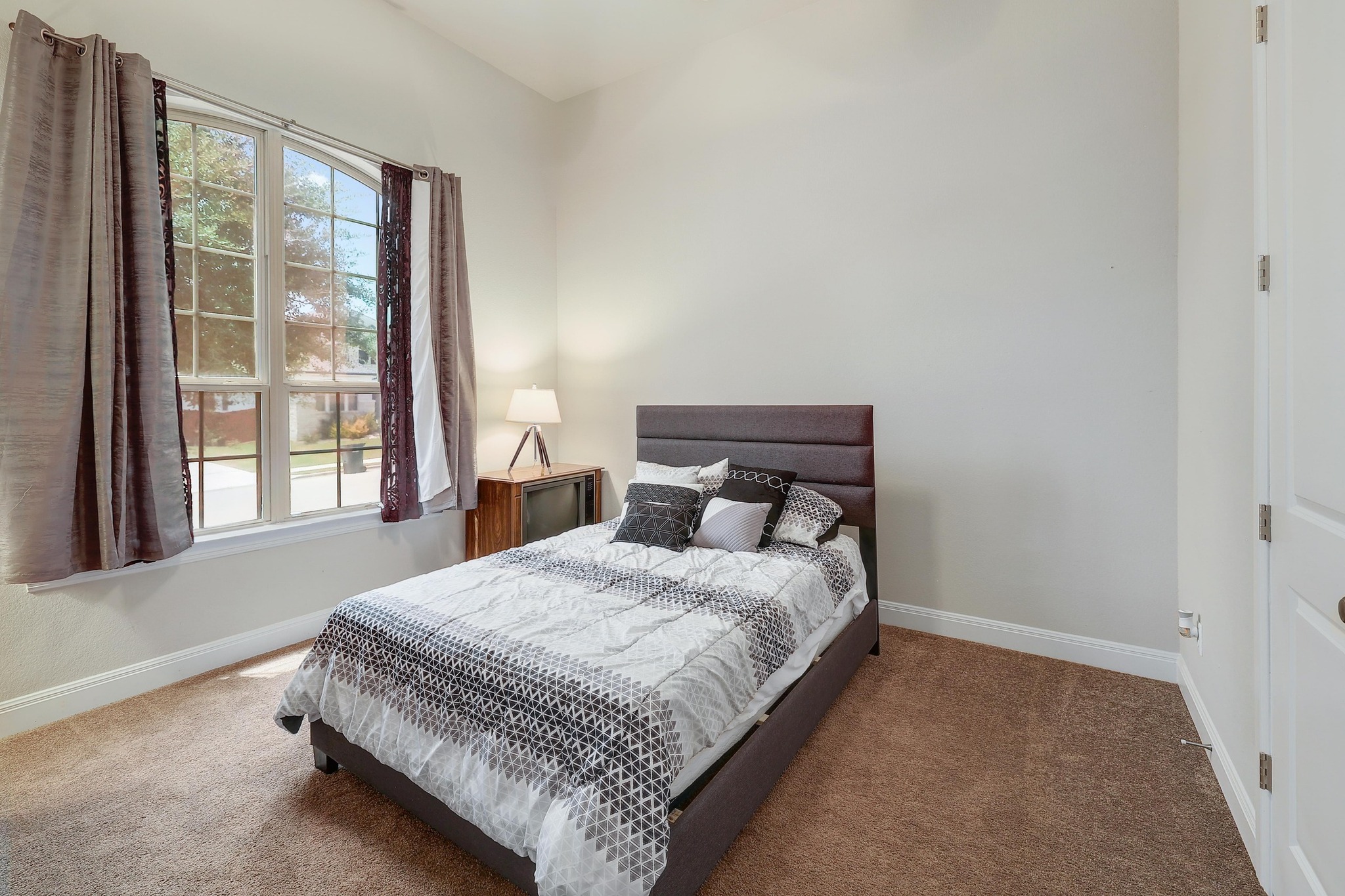 249 Axis Loop Georgetown, TX 78628 - Photo 21 of 36 a bedroom with a bed lamp and a large window