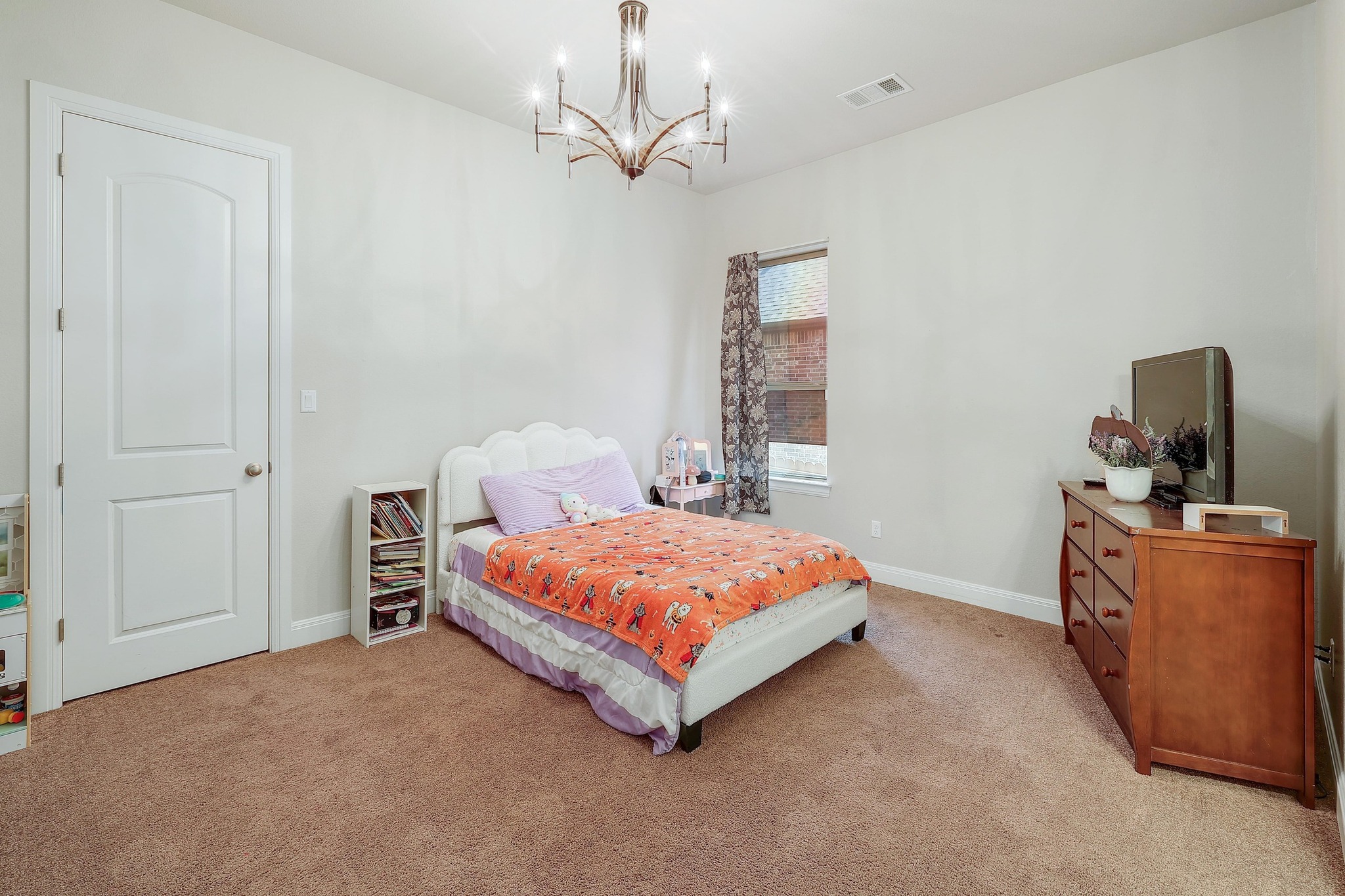 249 Axis Loop Georgetown, TX 78628 - Photo 22 of 36 a bedroom with a bed and a chandelier
