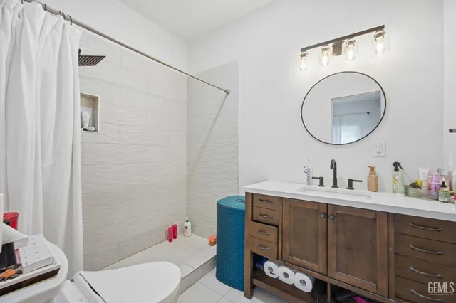 a bathroom with a toilet sink vanity tub and mirror