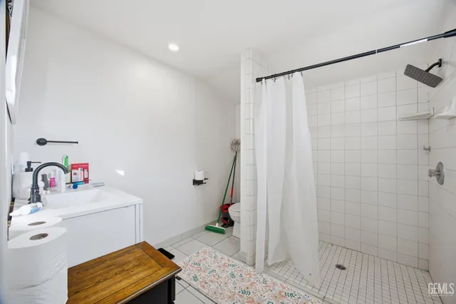 a bathroom with a sink a toilet and shower