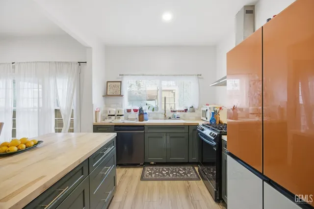 a kitchen with stainless steel appliances a sink a stove a refrigerator and cabinets