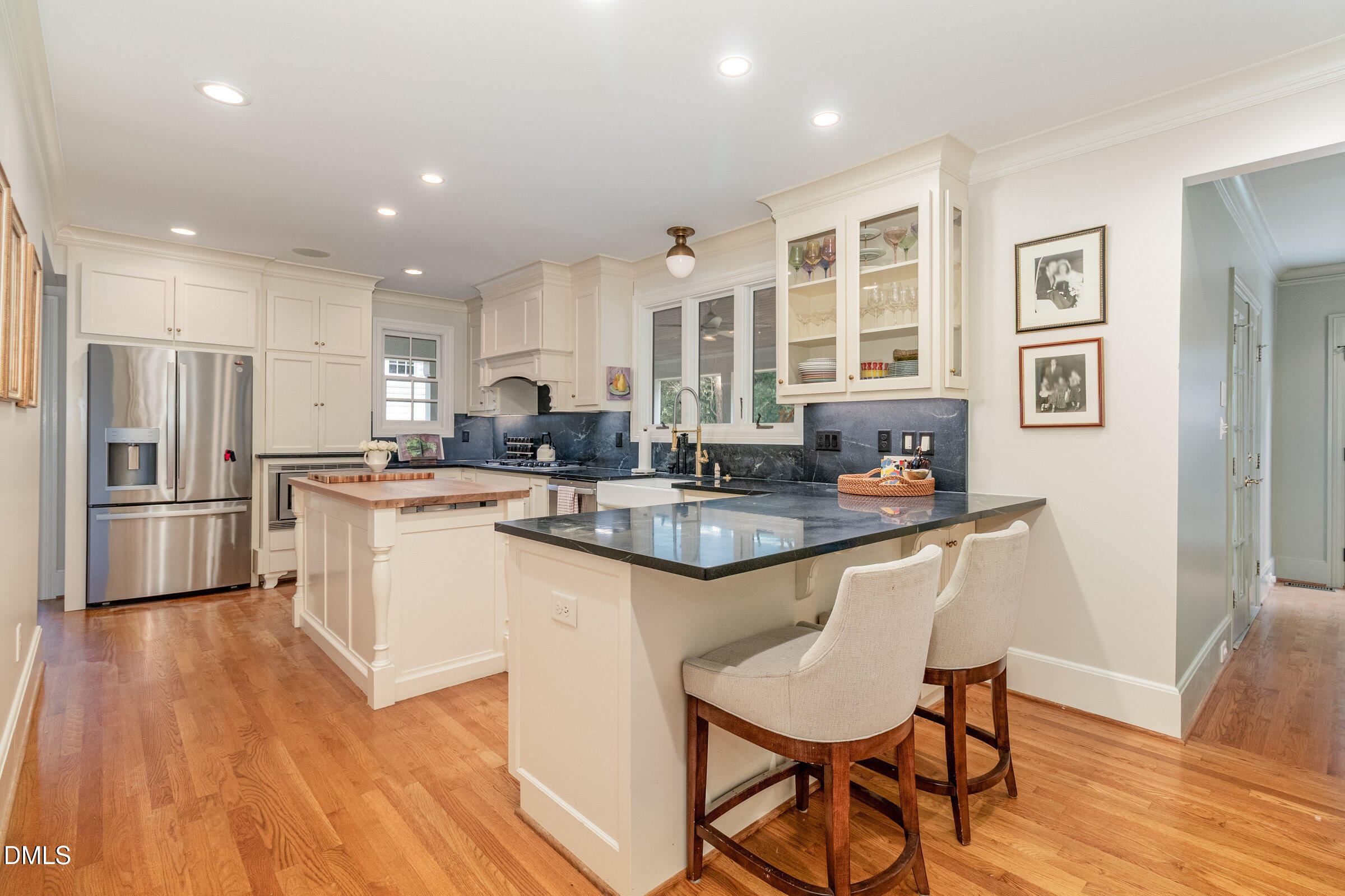 2404 Beechridge Road Raleigh, NC 27608 - Photo 16 of 52 a kitchen with stainless steel appliances granite countertop a stove a sink a refrigerator and chairs